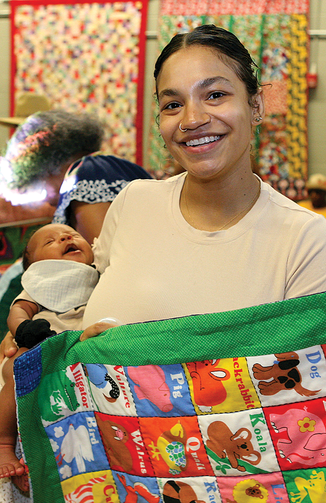 Lily Dillon with her newborn son, Silas, was pulled into the group and made her first quilt for her son with her newfound friends.