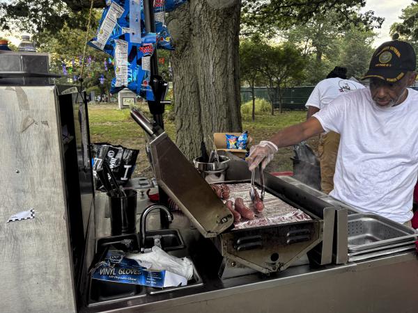 Michael Morris grills hot dogs and sausages behind the Boss Town Hot Dog cart. Madyline Swearing photo