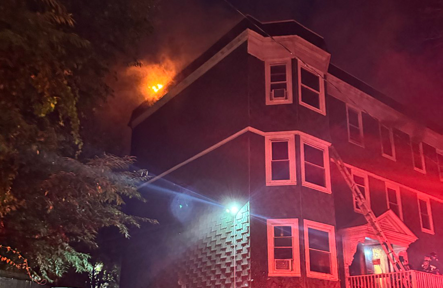 Fire erupts from roof of Becket Street three decker; photo by Boston FD